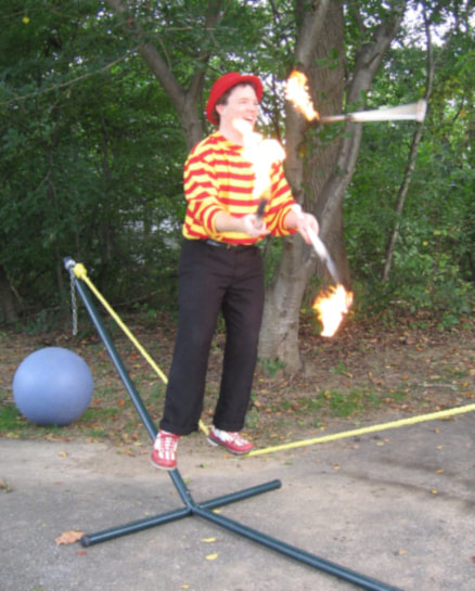 Greg May Fire Juggling Torches on Slack Rope