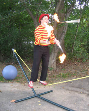 Fire Juggling while Slack Rope Walking Circus Tricks